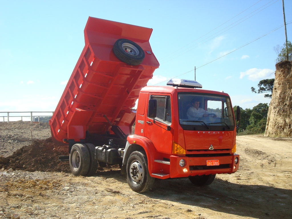 Caminhão basculante Agrale 13000 4x2 caçamba descarretando terra.