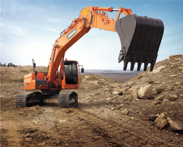 Escavadeira Doosan DX225 LCA em terreno rochoso.